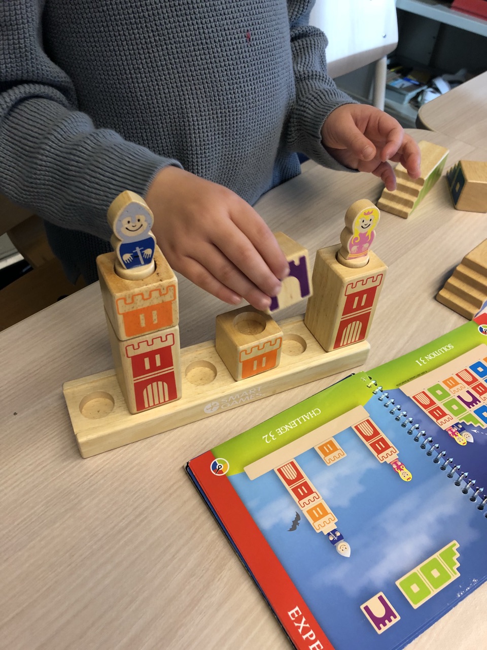 Kind speelt met educatief houten bouwspeelgoed aan tafel